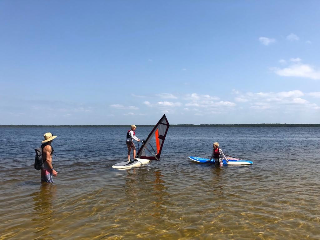 Enfants en cours de planche à voile en eau peu profonde